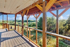 A wooden deck with a view of a forested landscape. - 2BR oceanview with spacious deck and wifi (Copalis Beach)