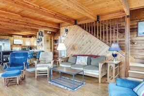A cabin interior with a wooden ceiling, a kitchen area, a sofa, a coffee table, and a staircase. - Spacious 2BR Oceanview Dog Friendly - Hot Tub (Port Angeles)