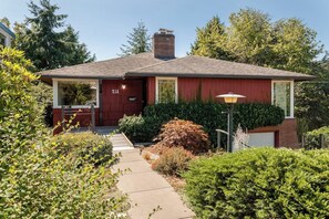 A single-story house with a red exterior, a chimney, and a front door labeled '213'. - Modern 3BR Bayview - Elevator - Deck - Washer Dryer (Seattle)