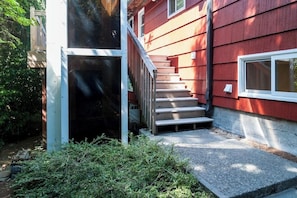 A red building with a staircase leading to a door. - Modern 3BR Bayview - Elevator - Deck - Washer Dryer (Seattle)