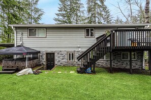 A two-story house with a stone facade, a covered patio, and a staircase leading to a balcony. - 2BR golf-side charmer with firepit & hot tub (Union)