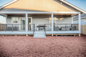 A house with a covered porch, a grill, and a small step leading to the entrance. - 3BR - Deck - Firepit - Washer Dryer (Westport)