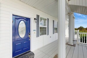 A white house with a blue front door, a covered porch, and a small front yard. - Steps to Beach 1BR Oceanfront Judith Ann Inn (Ocean Shores)