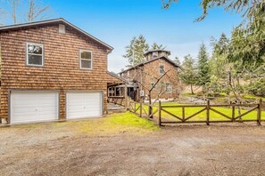 A two-story house with a garage and a fenced yard. - Stunning waterfront 3BR with firepit & woodstove (Camano Island)