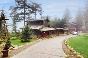 Eine Lodge mit überdachtem Gang, Holzfassade und einem geparkten Auto davor.