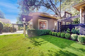 A residential property with a well-maintained lawn, a wooden deck, and a fenced backyard. - Serene Studio 1st-Floor - Deck - Kitchenette (Seattle)