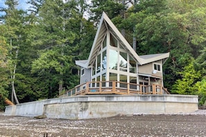 A multi-level wooden house with a balcony, surrounded by dense forest. - Stunning 3BR Oceanfront Dog Friendly - Dock (Tahuya)