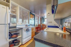Une cuisine équipée d’une cuisinière, d’un évier et d’un coin repas avec des chaises.