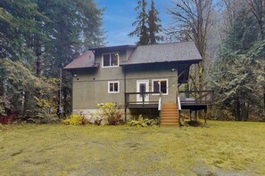 A two-story house with a deck and a staircase leading to a second-floor balcony.