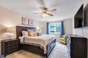 A bedroom with a bed, nightstands, a dresser, a ceiling fan, and a window with curtains. - Luxury 4BR Oceanfront - Chef's Kitchen- Pool (Tulalip)