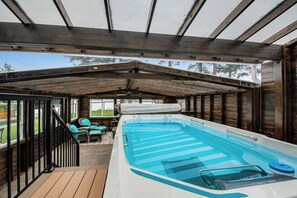 An indoor swimming pool with a wooden deck and seating area. - Luxury 4BR Oceanfront - Chef's Kitchen- Pool (Tulalip)