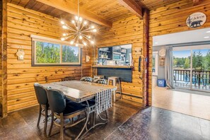 A wooden cabin interior with a dining area, kitchen, and large windows. - Dog-friendly 2BR lakefront cabin with amazing view (Tahuya)