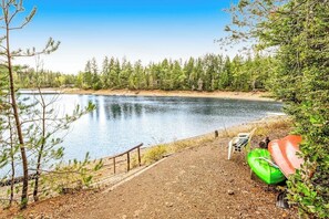 A lakeside view with a dirt path leading to a dock, surrounded by trees. - Dog-friendly 2BR lakefront cabin with amazing view (Tahuya)