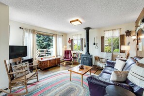 A cozy living room with a fireplace, a television, and comfortable seating. - Large 2BR Oceanfront - Deck - Firepit - Washer Dryer (Camano Island)