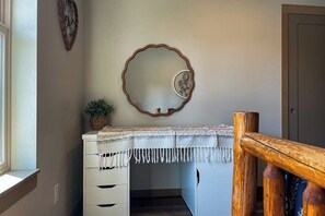 A room with a desk, a mirror, a plant, and a door. - 4BR Home with fire pit & pickleball and basketball court (Cle Elum)