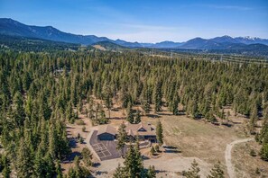A lodge surrounded by dense forest and mountains. - 4BR Home with fire pit & pickleball and basketball court (Cle Elum)