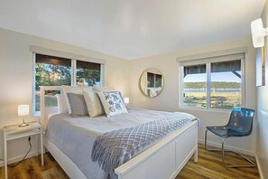 A bedroom with a bed, bedside tables, a chair, and large windows with a view. - Amazing View 2BR Soundview - Deck (Nordland)