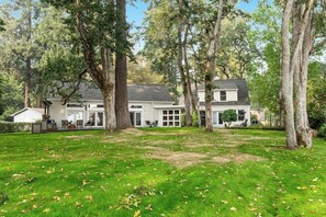 Ein Haus mit Vorgarten, umgeben von Bäumen.