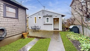 Een woonhuis met een klein terras, een gelijkvloers huis en een omheinde tuin.