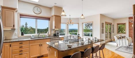 A spacious kitchen with a large island, wooden cabinets, and a skylight.
