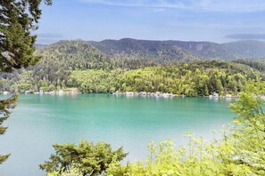 Un lago circondato da colline boscose sotto un cielo sereno.