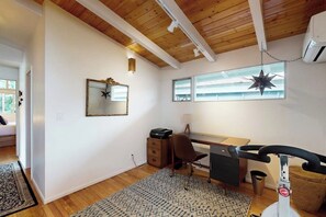 A room with a wooden ceiling, a desk with a chair, a printer, a star-shaped hanging decoration, and a window. - 1BR Home- Tranquil Mid-Century retreat (Seattle)