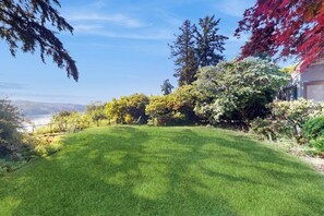 Une pelouse verdoyante et bien entretenue, avec vue sur un lac et des arbres.