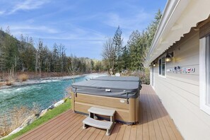 A hot tub on a wooden deck with a river view. - Upgraded 3BR Riverfront - Hot Tub - WoodStove (Sultan)