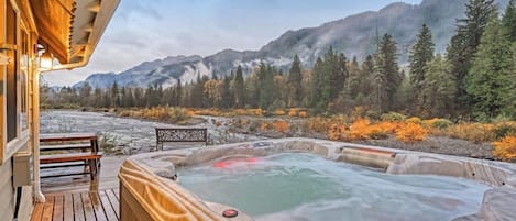 Un jacuzzi en una terraza de madera con vistas a la montaña.