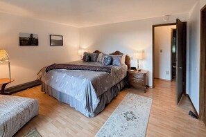 A bedroom with a bed, bedside tables, a nightstand, a chair, a rug, and a door. - 3BR Secluded home near downtown Washer Dryereck & grill (Woodinville)