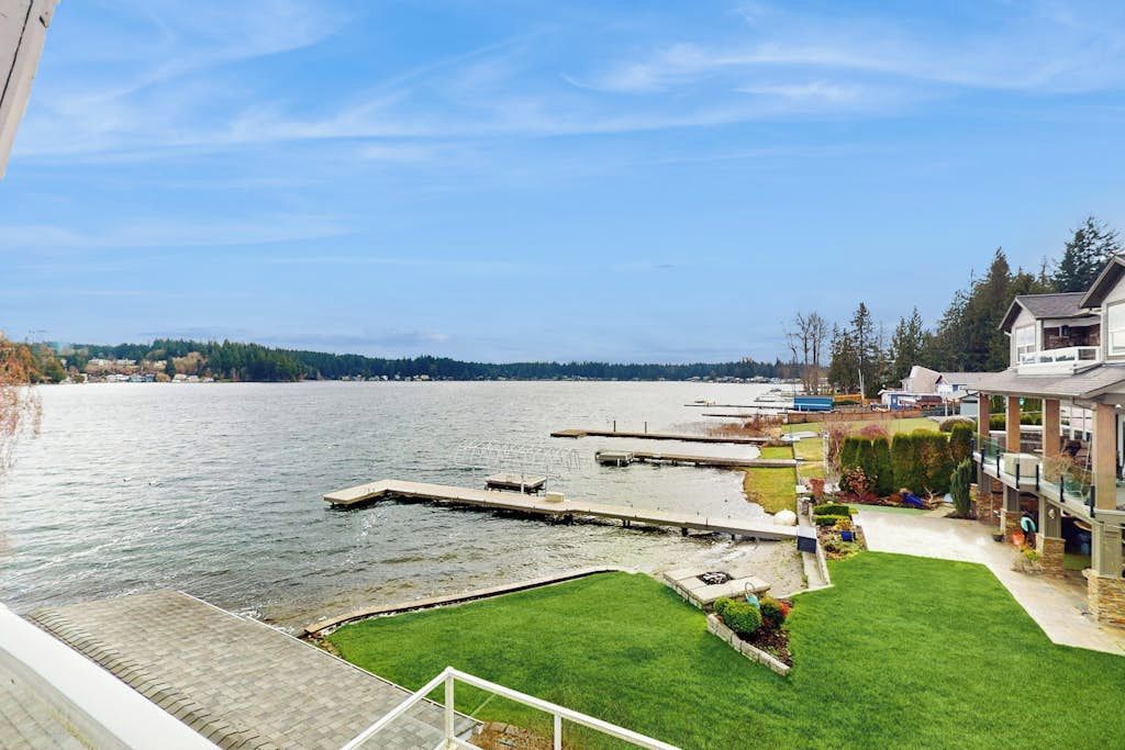 Ein Wohngebiet mit Uferpromenade, einem Steg und einem gepflegten Rasen.