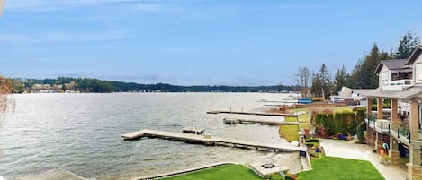 Zona residencial con vista al agua, un muelle y un césped cuidado.