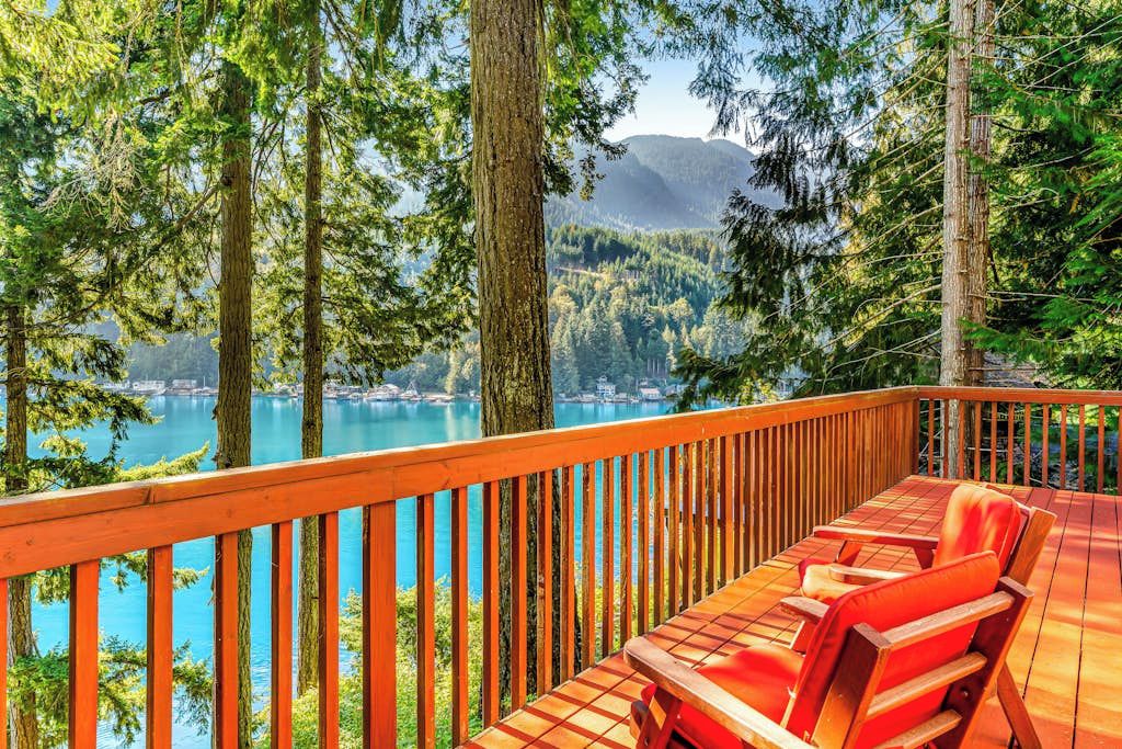 Une terrasse avec vue sur un lac et une forêt.