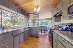 A modern kitchen with a wooden ceiling, large windows, and a central island. - Fantastic 2BR Lakefront - Dock - Fireplace (Grapeview)