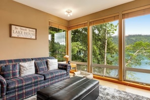 A living room with a large window, a sofa, and a coffee table.