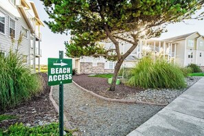 Schild, das den Zugang zum Strand mit einem Pfeil anzeigt.