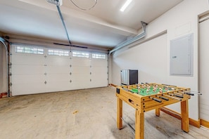 A garage with a foosball table, a white garage door, and a door with a handle. - BlackBearLodge 4BR with ensuites - walk everywhere (Cle Elum)