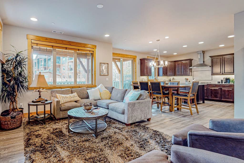 A spacious living area with a sofa set, a coffee table, and a dining table with chairs.