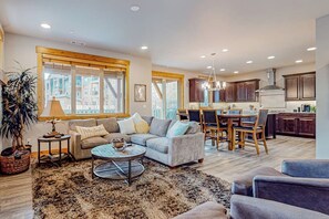 A spacious living area with a sofa set, a coffee table, and a dining table with chairs. - BlackBearLodge 4BR with ensuites - walk everywhere (Cle Elum)