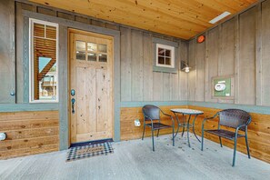 A wooden exterior with a door, two chairs, a small table, and a window. - BlackBearLodge 4BR with ensuites - walk everywhere (Cle Elum)