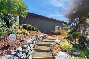 A modern house with a stone pathway leading to the entrance, surrounded by a landscaped garden. - 1BR Home great for work, play, easy Seattle access (Bainbridge Island)