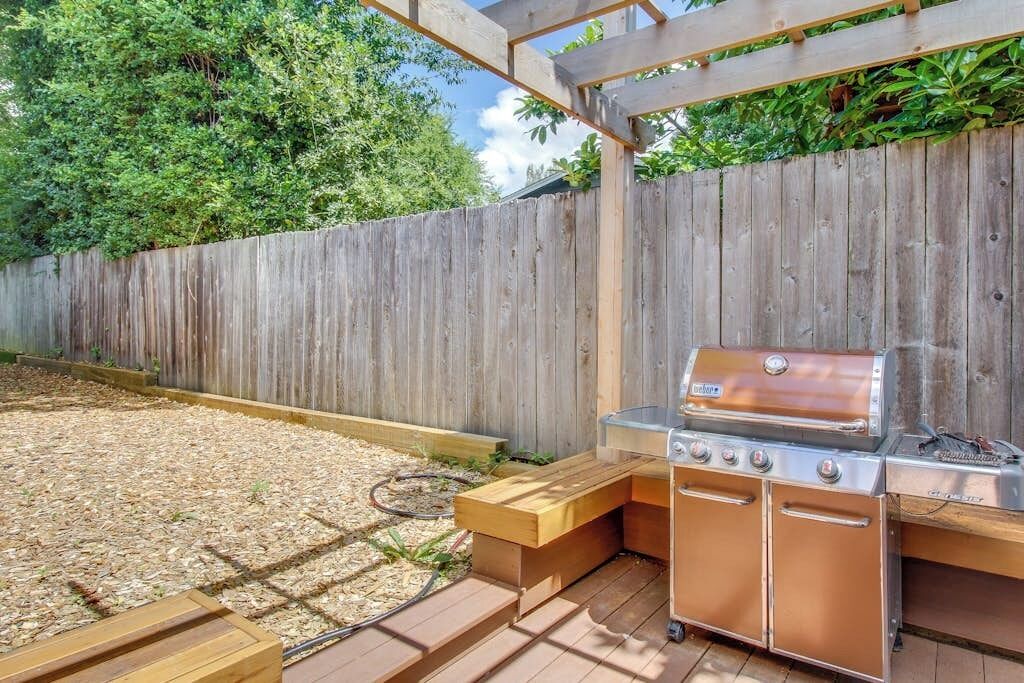 An outdoor barbecue area with a built-in grill and seating.