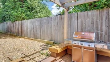 An outdoor barbecue area with a built-in grill and seating.