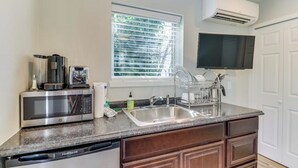 A kitchen with a built-in microwave, a dishwasher, a sink, and a window with blinds. - Downtown | Lakeview | Deck | Hot Tub (Mercer Island)
