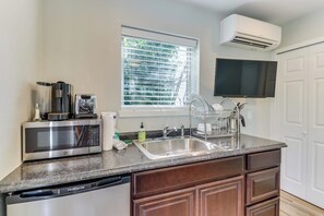 A kitchen with a built-in microwave, a dishwasher, a sink, and a window with blinds. - Downtown | Lakeview | Deck | Hot Tub (Mercer Island)