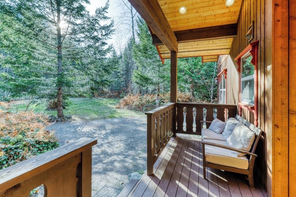 Une terrasse en bois avec un banc et une vue sur une zone boisée.