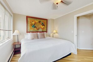 A hotel room with a large bed, two bedside lamps, a ceiling fan, and a decorative tapestry on the wall. - Downtown 1BR Washington State Conv. Center 14th-fl (Seattle)