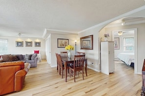 A spacious living area with a wooden floor, a dining table with chairs, a sofa, and a bed in the background. - Downtown 1BR Washington State Conv. Center 14th-fl (Seattle)