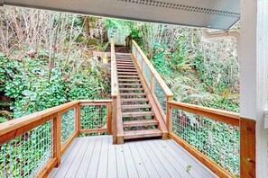 A wooden staircase leading up to a covered area with a metal railing, surrounded by greenery. - 4 BR waterfront home on Camano Island (Camano Island)