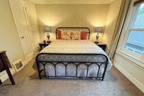A bedroom with a bed, two bedside tables, lamps, a window, and a door. - Lovely 4BR Lakeview - Game Room - Foosball (Seattle)
